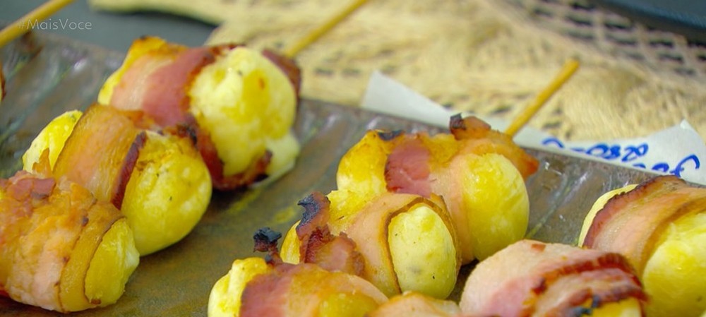 Espetinhos de mandioca com queijo e bacon, prontos para serem servidos.