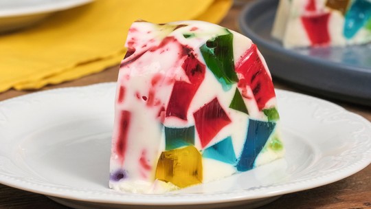 Gelatina colorida em camadas, servida em um copo.
