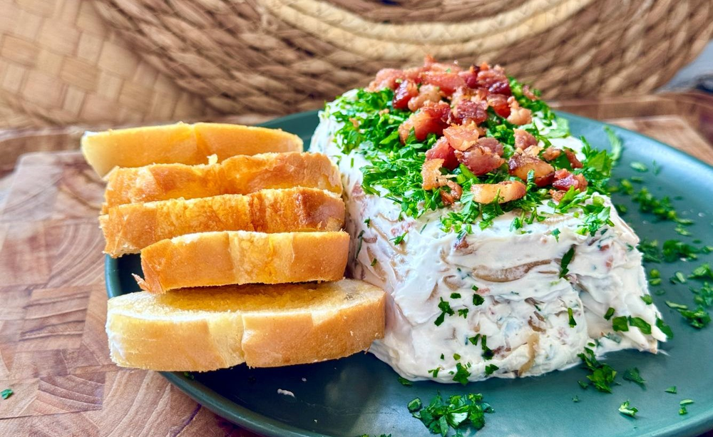 Patê de cebola caramelizada com bacon cremoso servido em uma tigela, ao lado de torradas e ervas frescas, para a ceia de Réveillon.