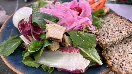 Picles variados, incluindo pepino e cebola, em potes de vidro