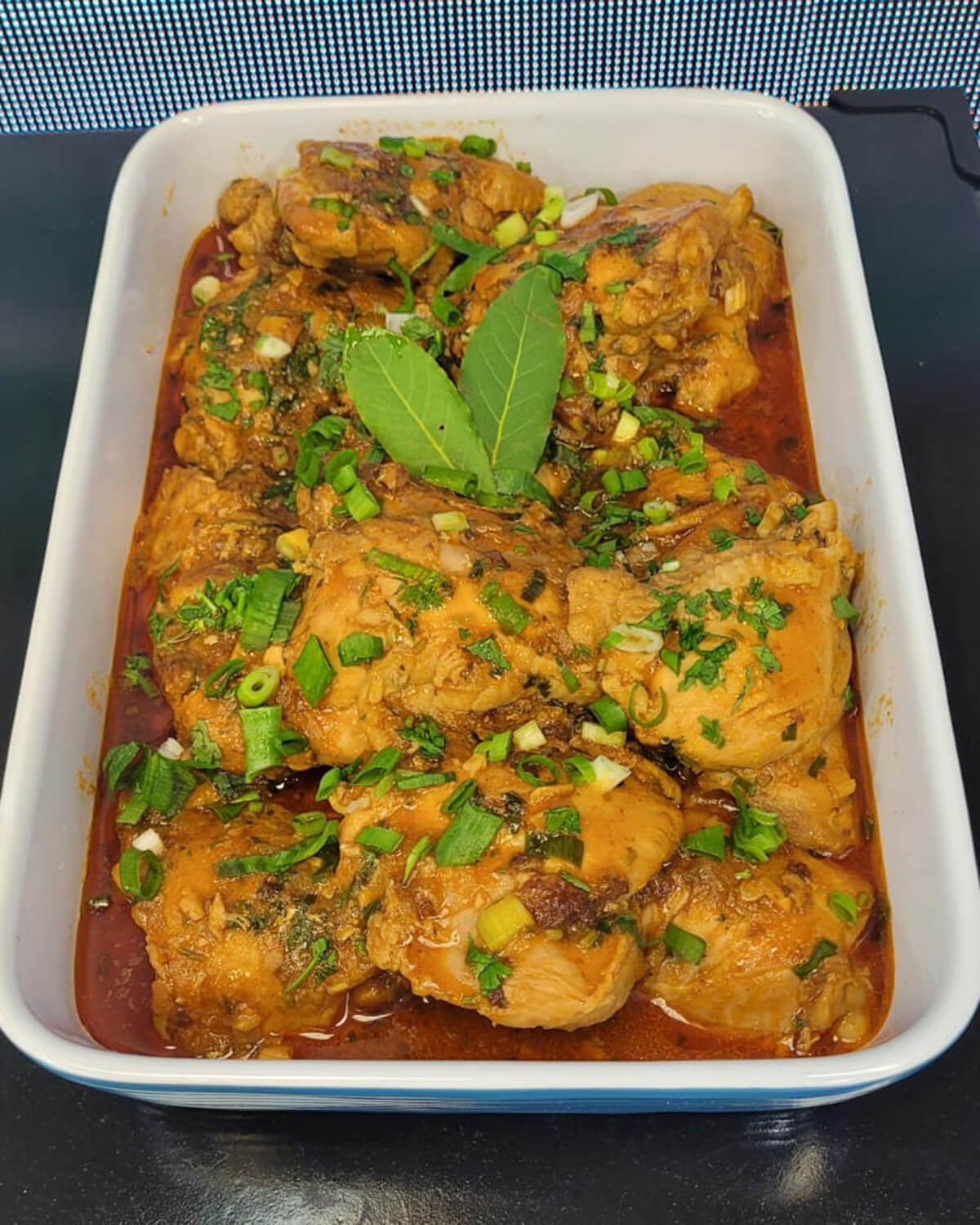 Chicken pieces simmering in a rustic tomato sauce in a pan
