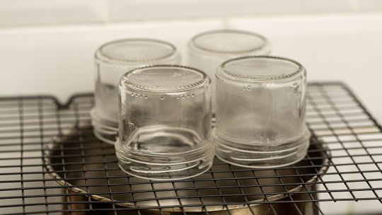 Potes de vidro sendo esterilizados com água quente