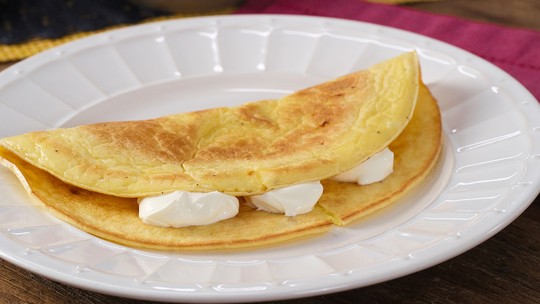 Crepioca com requeijão em uma frigideira com recheio aparente