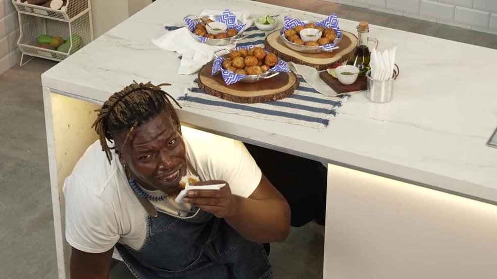 Pega a referência: Digão Ribeiro passa por debaixo da mesa ao experimentar o bolinho de bacalhau | Foto: Receitas