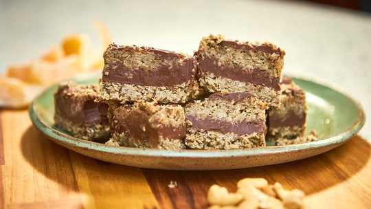 Barrinhas de aveia com chocolate em uma tábua, prontas para o lanche